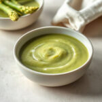 Cream of asparagus soup in a bowl, showcasing its creamy texture and vibrant green color. — cream of asparagus soup slow cooker