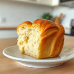 Plated cruffin, a croissant-muffin hybrid, showcasing its flaky layers and golden-brown crust.