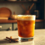 A finished glass of pumpkin spice dirty soda topped with whipped cream and a sprinkle of cinnamon.
