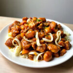 Plated slow cooker chicken chili with visible beans and chicken in a bowl.